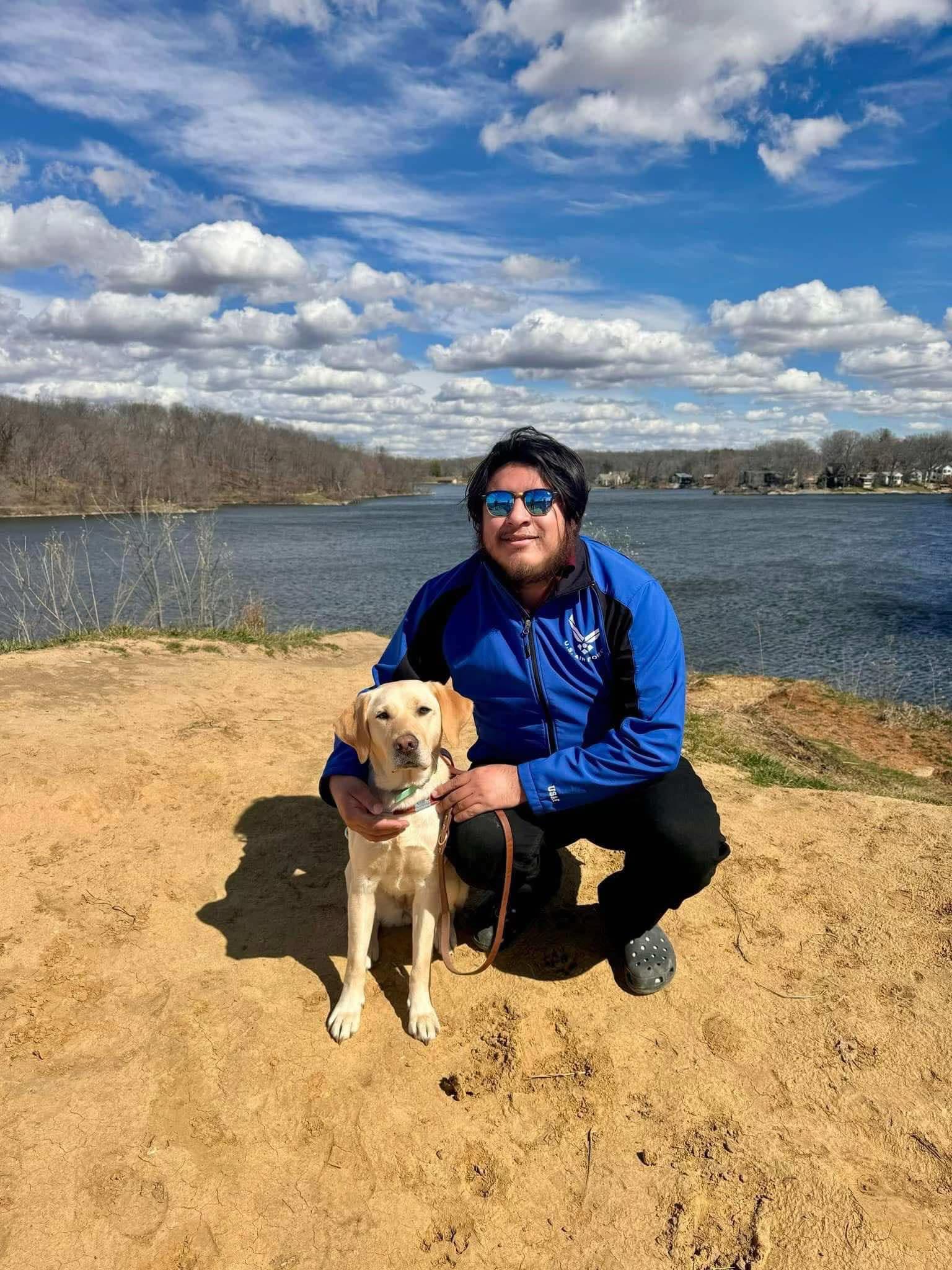 Fernando Jimenez and a yellow Labrador Retriever in a field